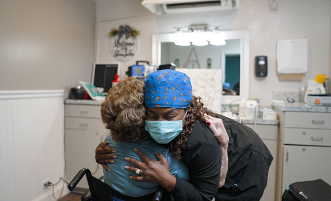 Dr. Sonya Dunbar embracing a patient during an on-site dental visit